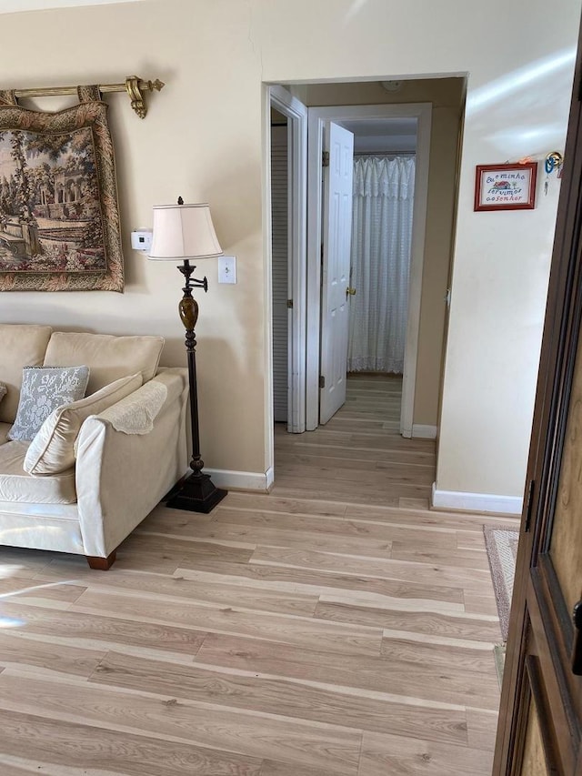 living area with light wood-style floors and baseboards