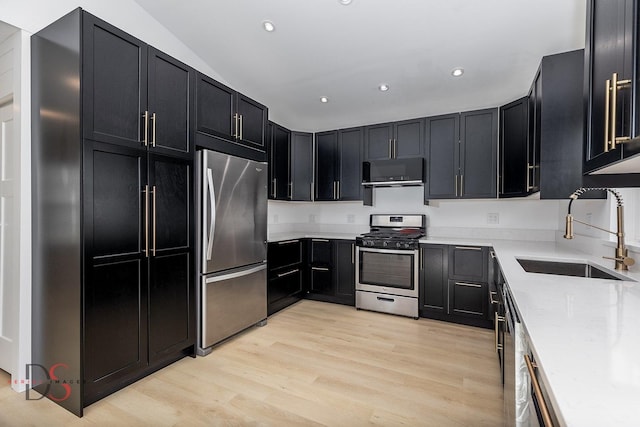 kitchen featuring appliances with stainless steel finishes, light hardwood / wood-style floors, sink, and light stone countertops