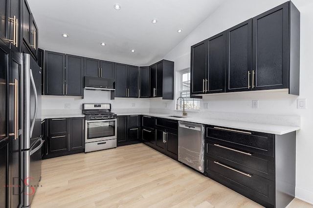 kitchen with stainless steel appliances, sink, and light hardwood / wood-style flooring