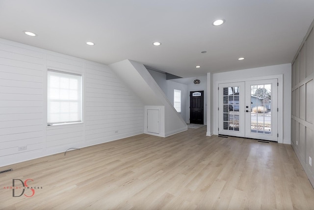 additional living space featuring french doors and light wood-type flooring