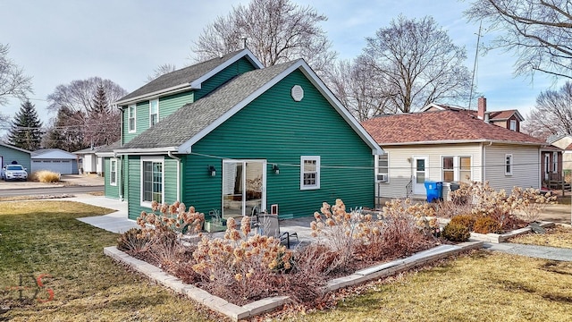 back of property featuring a garage, a yard, and a patio area