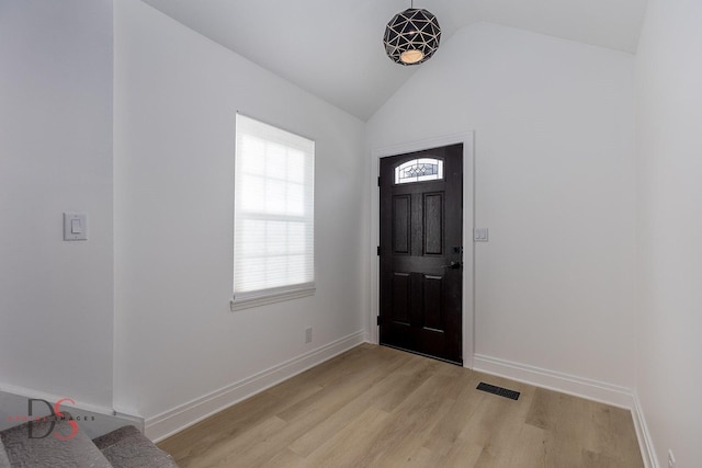 foyer featuring vaulted ceiling, plenty of natural light, and light hardwood / wood-style floors