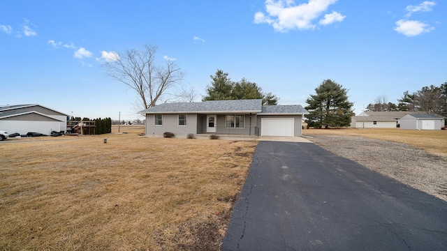 ranch-style house featuring a garage, a front lawn, and covered porch