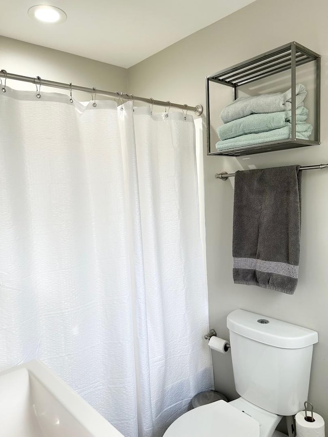 bathroom with a shower with curtain and toilet