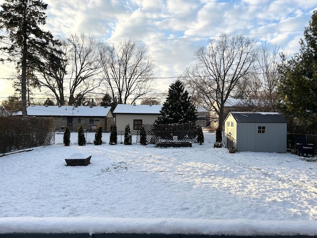 yard layered in snow featuring a storage shed