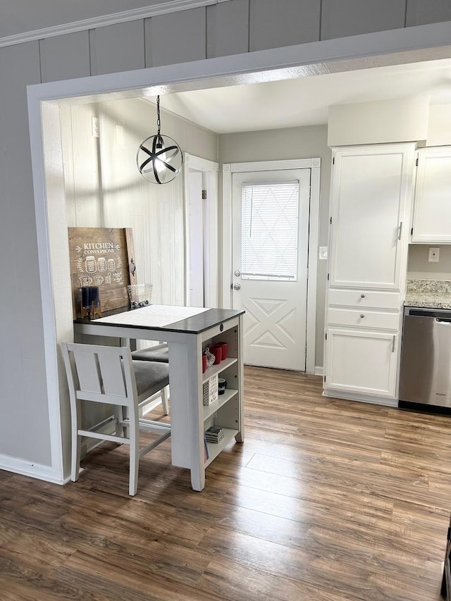 kitchen with pendant lighting, white cabinets, wood-type flooring, and dishwasher