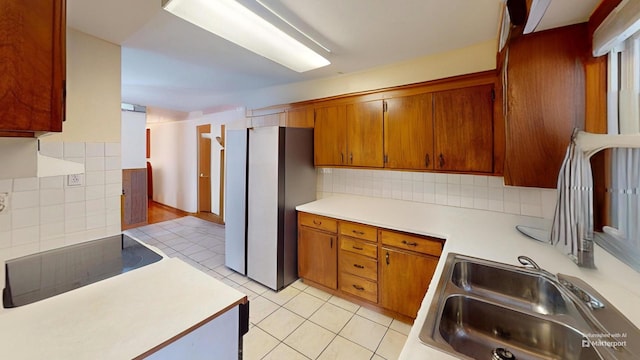 kitchen with tasteful backsplash, light tile patterned flooring, sink, and black electric cooktop