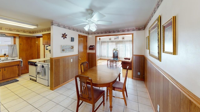 dining space featuring light tile patterned flooring, ceiling fan, and sink