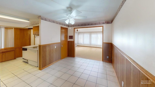 kitchen with ceiling fan, wooden walls, and light tile patterned floors