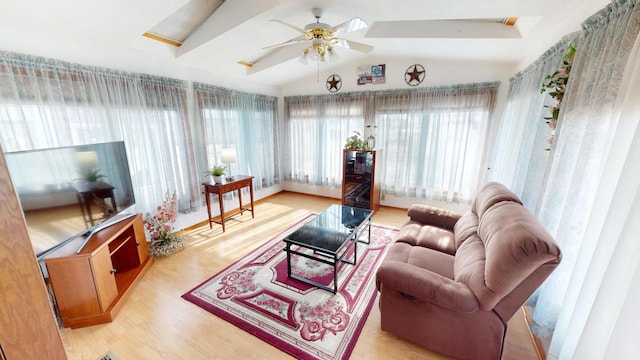 living room with vaulted ceiling, ceiling fan, and light wood-type flooring