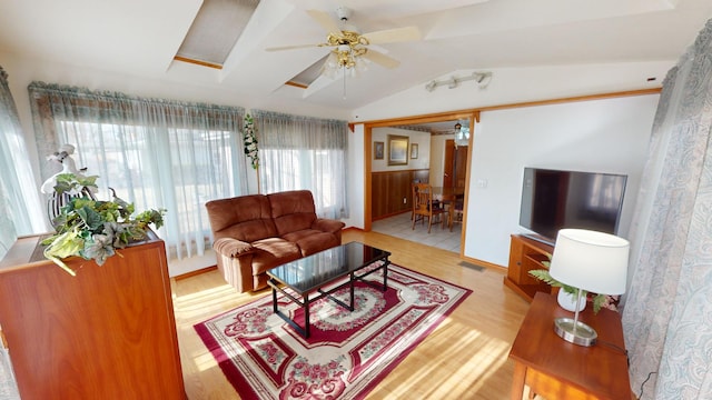 living room featuring lofted ceiling, ceiling fan, and light wood-type flooring