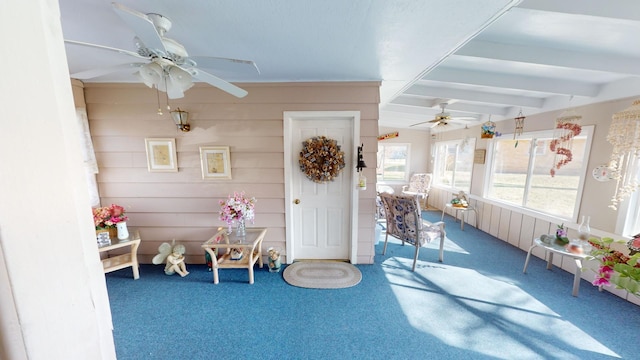 sunroom featuring beamed ceiling and ceiling fan