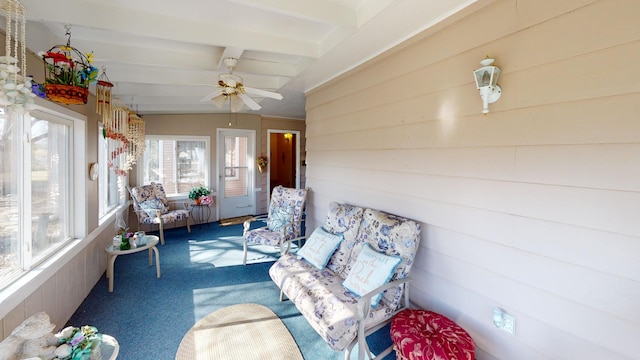 sunroom featuring beamed ceiling and ceiling fan