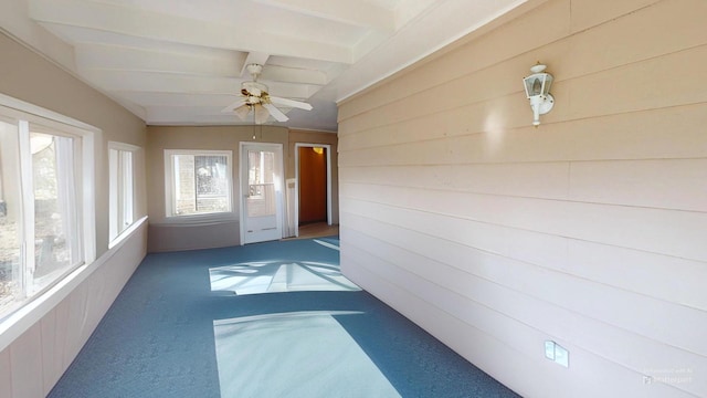 unfurnished sunroom featuring beamed ceiling