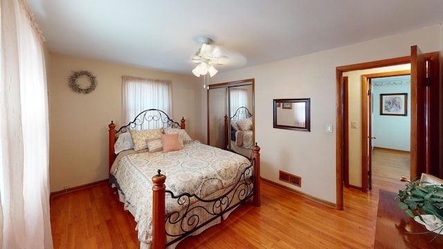 bedroom featuring light hardwood / wood-style flooring, a closet, and ceiling fan