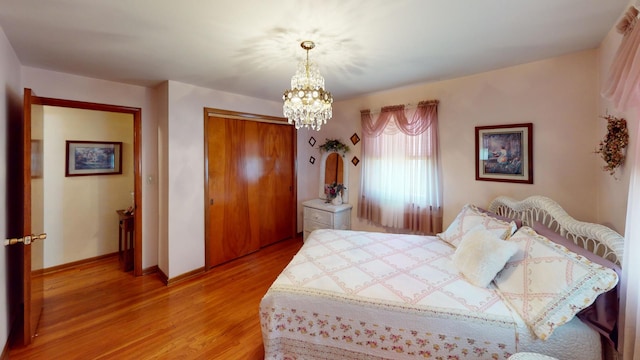 bedroom featuring light hardwood / wood-style floors, a closet, and a notable chandelier