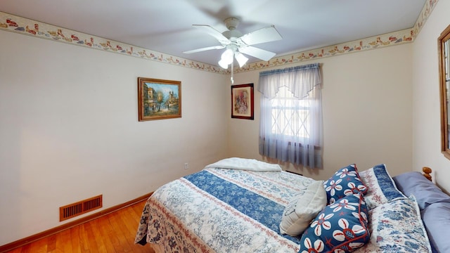 bedroom with ceiling fan and hardwood / wood-style floors