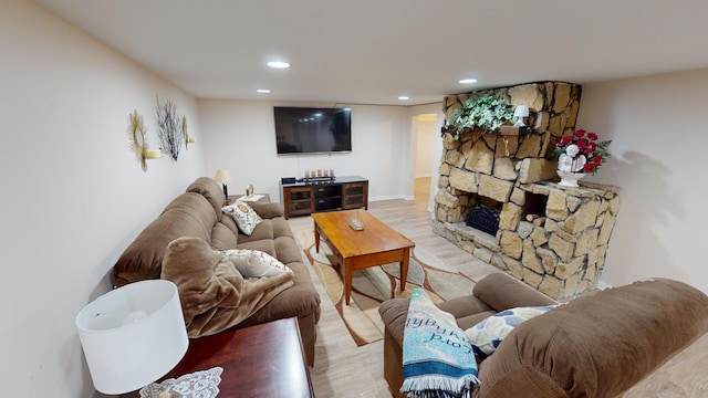 living room with a fireplace and light wood-type flooring