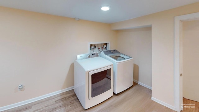 washroom featuring washing machine and dryer and light wood-type flooring