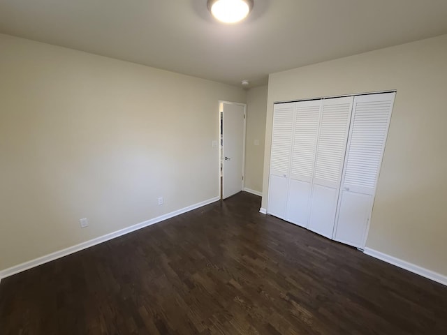 unfurnished bedroom featuring dark hardwood / wood-style floors and a closet