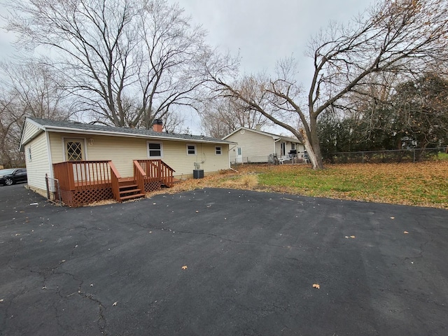 back of property with a wooden deck and central AC unit