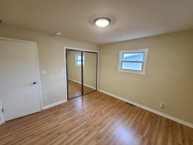 unfurnished bedroom featuring light hardwood / wood-style floors and a closet