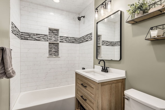 full bathroom featuring vanity, tiled shower / bath combo, and toilet