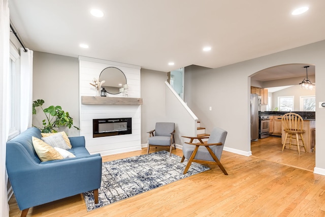 living room featuring a large fireplace and light hardwood / wood-style floors