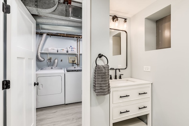 laundry room featuring sink, light hardwood / wood-style flooring, and washer and dryer