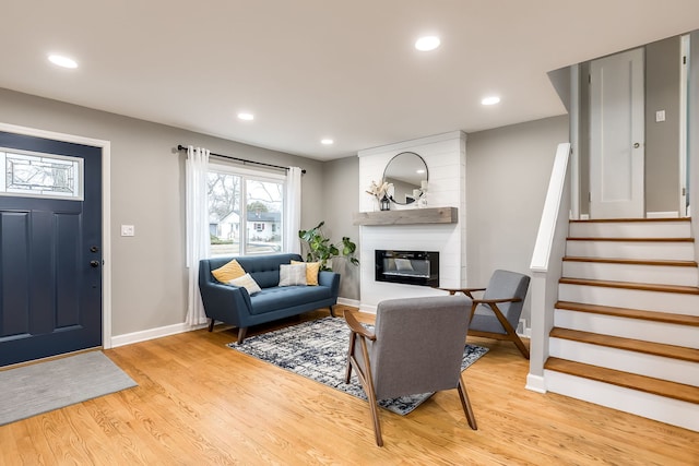 living room with a large fireplace and light hardwood / wood-style floors