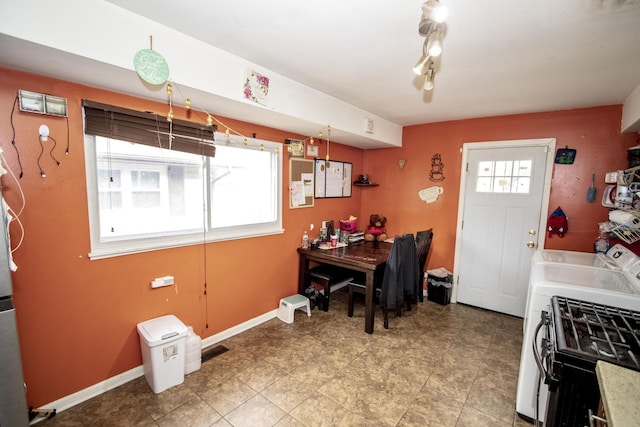 kitchen with gas range, a wealth of natural light, and washing machine and dryer