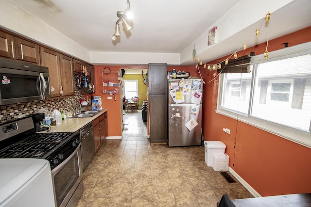 kitchen featuring backsplash, stainless steel appliances, and sink