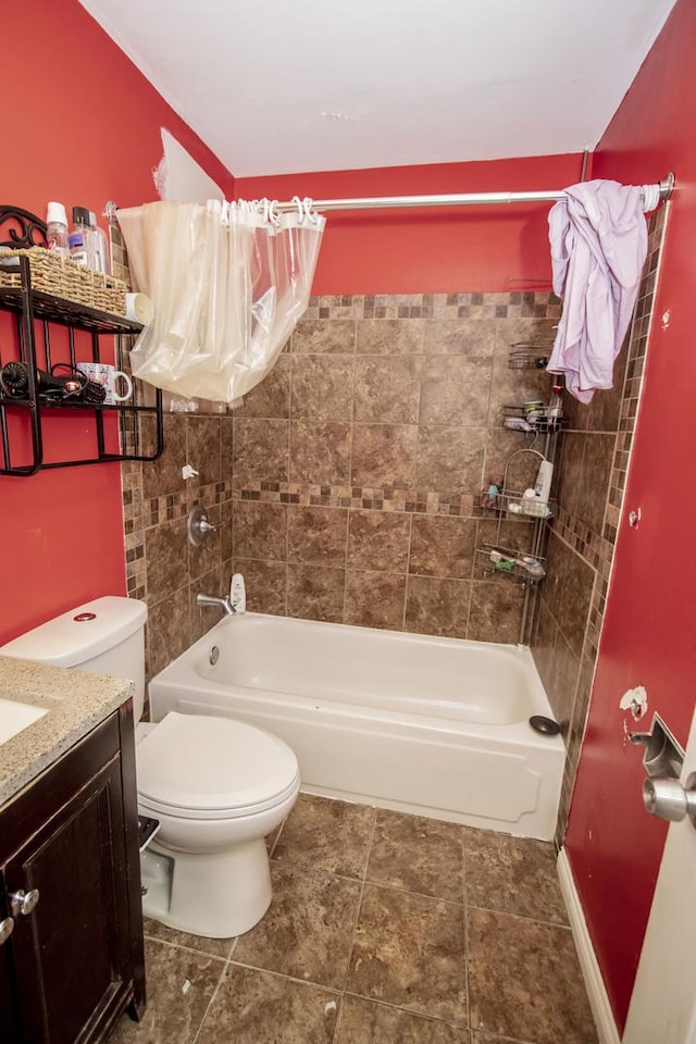 full bathroom featuring tiled shower / bath, vanity, and toilet