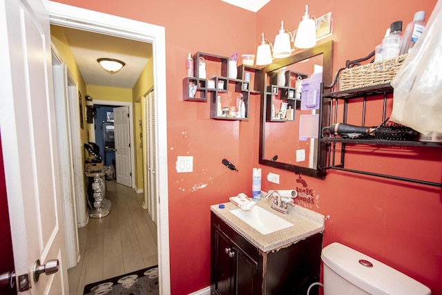 bathroom featuring vanity, hardwood / wood-style floors, and toilet