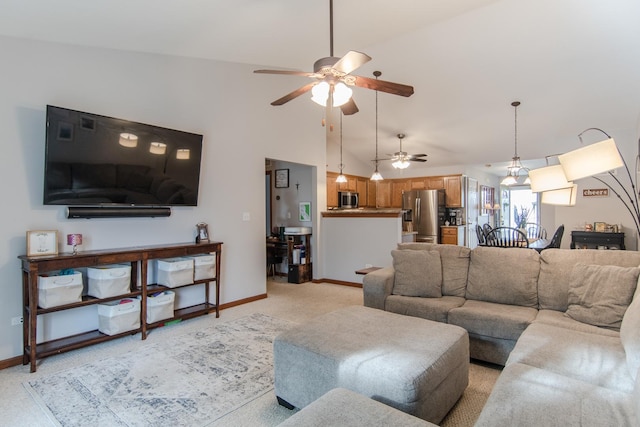 carpeted living room with ceiling fan and high vaulted ceiling