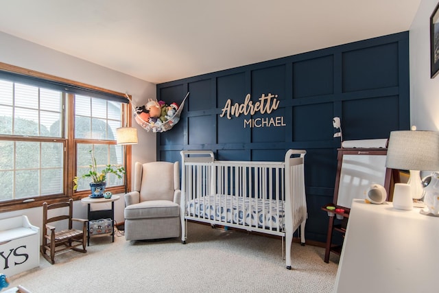 bedroom with a nursery area and carpet