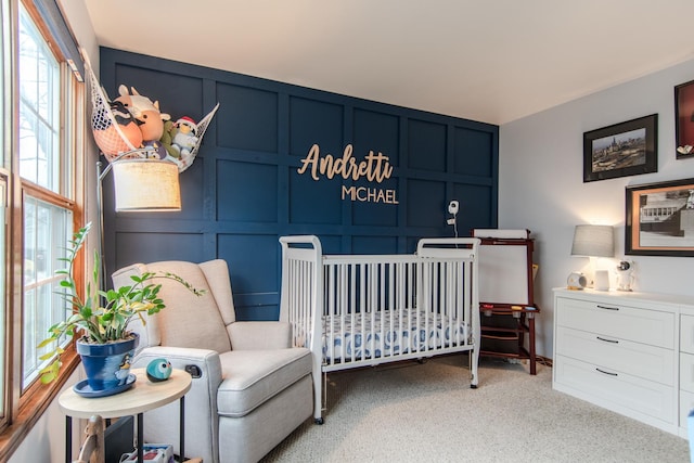 bedroom with light colored carpet and a crib