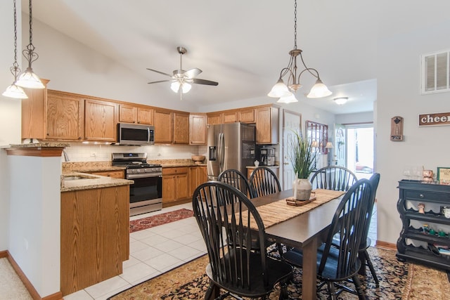 tiled dining room featuring vaulted ceiling, ceiling fan, and sink