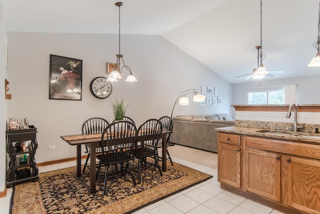 tiled dining room featuring sink, vaulted ceiling, and ceiling fan