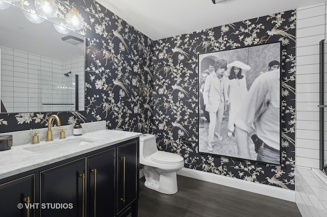 bathroom featuring wood-type flooring, toilet, vanity, and a shower