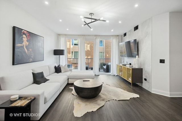 living room with a notable chandelier and dark wood-type flooring