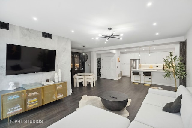 living room with dark wood-type flooring and a chandelier