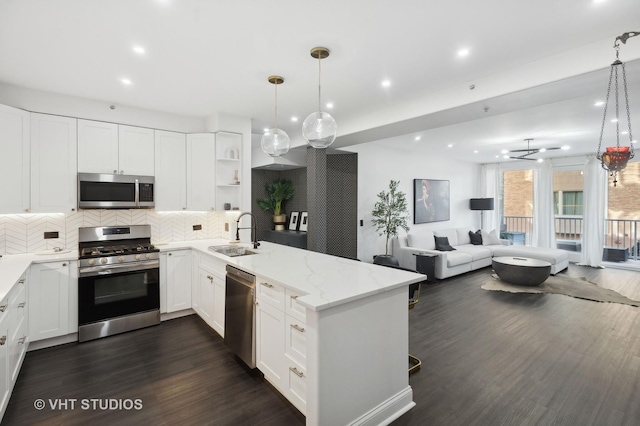 kitchen with white cabinetry, stainless steel appliances, and decorative light fixtures