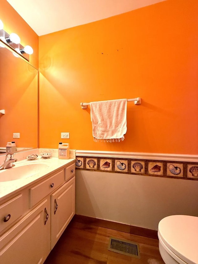 bathroom featuring vanity, toilet, and hardwood / wood-style floors