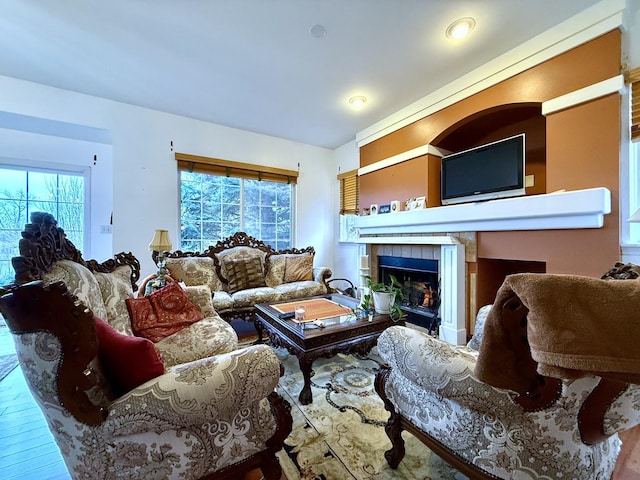 living room featuring hardwood / wood-style flooring, a healthy amount of sunlight, and a tile fireplace