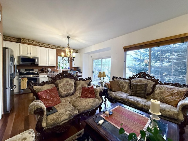 living room with dark hardwood / wood-style floors and a notable chandelier