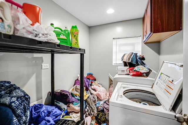 laundry area featuring washer and clothes dryer and cabinets