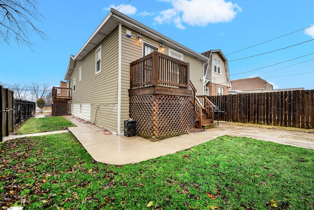 rear view of house featuring a wooden deck, a yard, and a patio