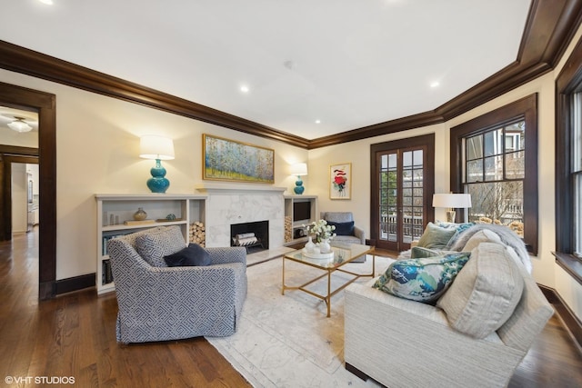 living room with dark hardwood / wood-style floors, ornamental molding, a fireplace, and french doors