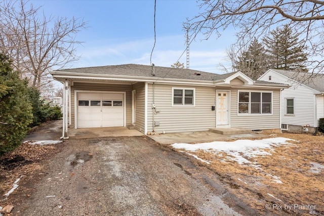 single story home with a garage and aphalt driveway